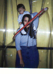 girl inside giant soap bubble with baby on her shoulders